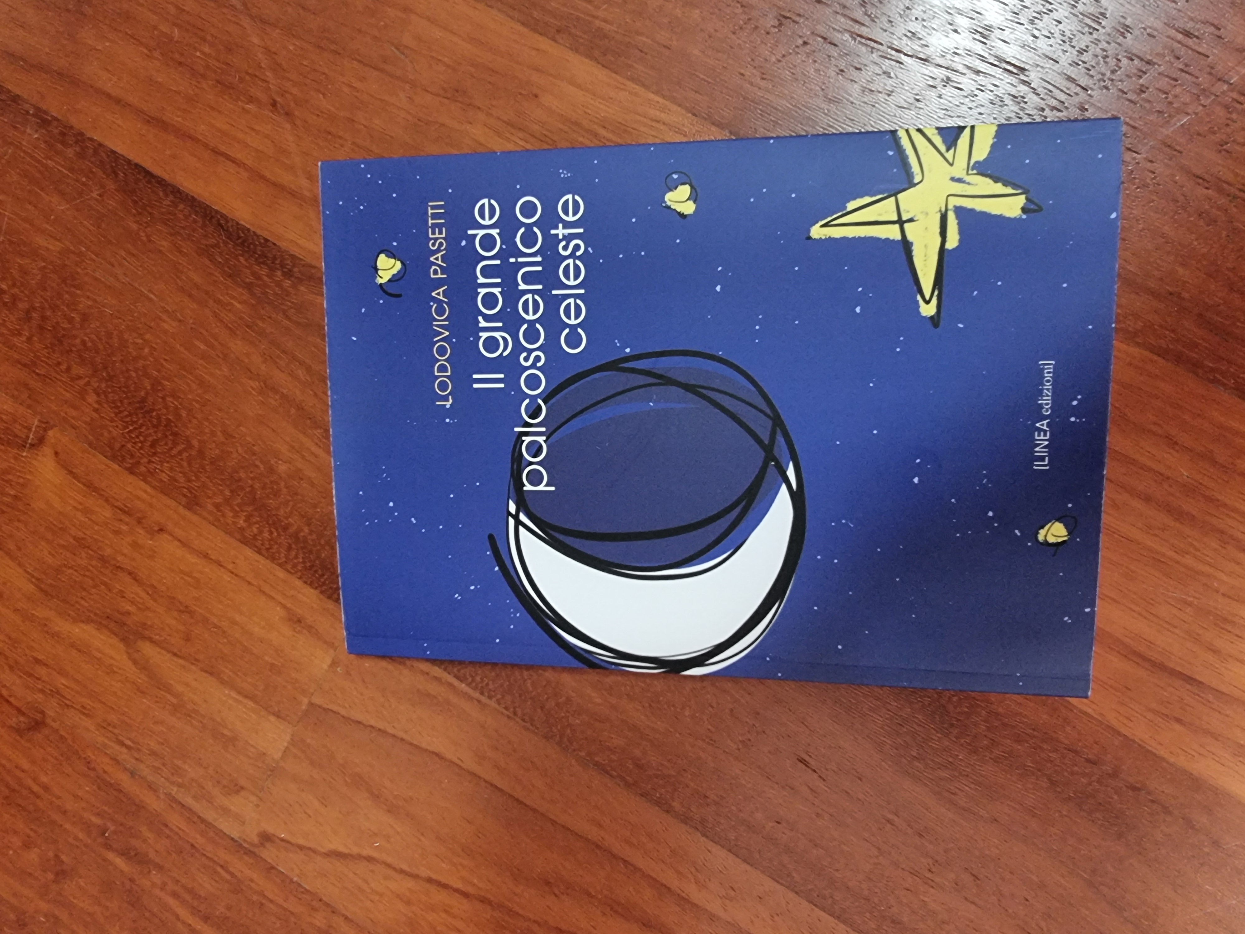 Il libro Il grande palcoscenico celeste di Lodovica Pasetti, con copertina blu, Luna e stelle